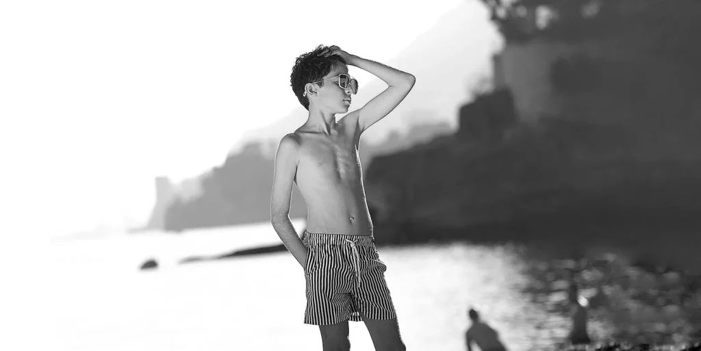 Portrait d’un jeune garçon modèle portant un maillot Costume de Sable au soleil couchant à Cap d’ail